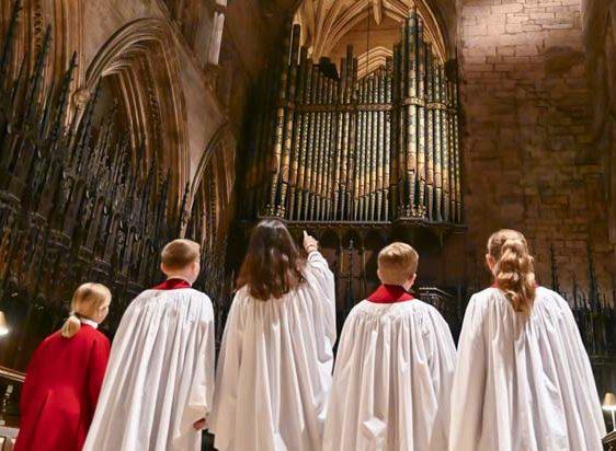 Children in a cathedral pointing at the grand organ